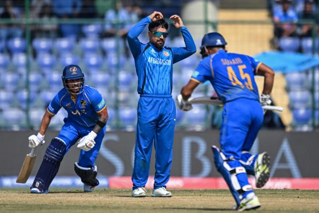 Afghanistan's captain Rashid Khan (C) reacts as UAE's Sohaib Khan (R) and Haider Shah run between the wickets during the 2026 ICC Men's T20 Cricket World Cup group stage match between Afghanistan and United Arab Emirates at the Arun Jaitley Stadium in New Delhi on February 16, 2026. (Photo by Arun SANKAR / AFP)