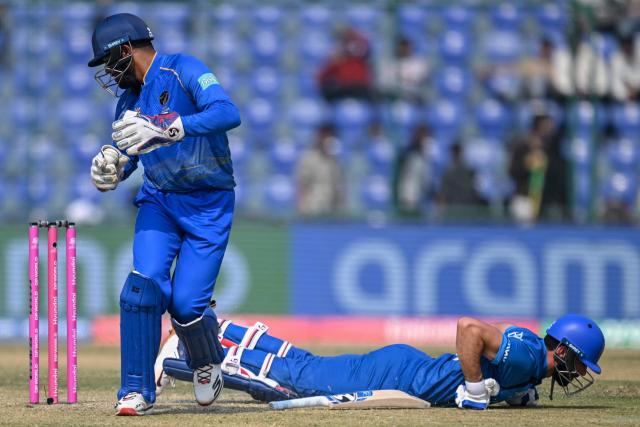 Afghanistan's Ibrahim Zadran (R) dives to reach inside the crease as UAE's Aryansh Sharma attempts to run him out during the 2026 ICC Men's T20 Cricket World Cup group stage match between Afghanistan and United Arab Emirates at the Arun Jaitley Stadium in New Delhi on February 16, 2026. (Photo by Arun SANKAR / AFP)