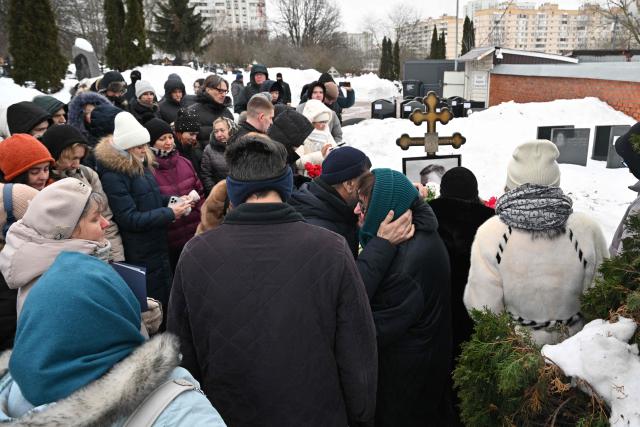 Lyudmila Navalnaya, mother of late Russian opposition leader Alexei Navalny, is comforted by a man as she visits her son's grave at the Borisovo cemetery in Moscow on February 16, 2026, marking the second anniversary of his death in an Arctic colony. (Photo by Hector RETAMAL / AFP) / NAVALNY HAS BEEN DECLARED "EXTREMIST" BY RUSSIAN AUTHORITIES. IN RUSSIA, ANYBODY WHO MENTIONS NAVALNY OR HIS ANTI-CORRUPTION FOUNDATION WITHOUT STATING THAT THEY HAVE BEEN DECLARED "EXTREMIST" IS SUBJECT TO FINES OR UP TO FOUR YEARS IN PRISON FOR REPEATED OFFENCES. / 