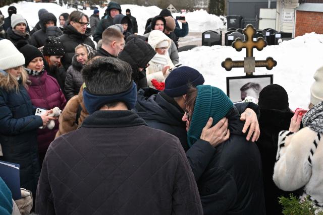 Lyudmila Navalnaya, mother of late Russian opposition leader Alexei Navalny, is comforted by a man as she visits her son's grave at the Borisovo cemetery in Moscow on February 16, 2026, marking the second anniversary of his death in an Arctic colony. (Photo by Hector RETAMAL / AFP) / NAVALNY HAS BEEN DECLARED "EXTREMIST" BY RUSSIAN AUTHORITIES. IN RUSSIA, ANYBODY WHO MENTIONS NAVALNY OR HIS ANTI-CORRUPTION FOUNDATION WITHOUT STATING THAT THEY HAVE BEEN DECLARED "EXTREMIST" IS SUBJECT TO FINES OR UP TO FOUR YEARS IN PRISON FOR REPEATED OFFENCES. / 