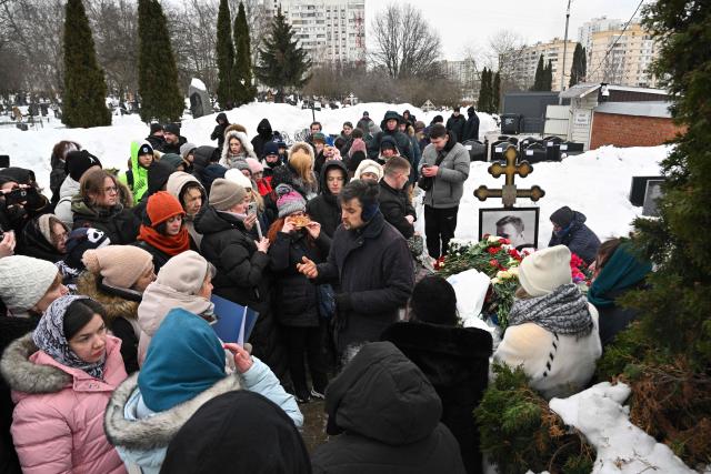 People visit the grave of Russian opposition leader Alexei Navalny at the Borisovo cemetery in Moscow on February 16, 2026, marking the second anniversary of his death in an Arctic colony. (Photo by Hector RETAMAL / AFP) / NAVALNY HAS BEEN DECLARED "EXTREMIST" BY RUSSIAN AUTHORITIES. IN RUSSIA, ANYBODY WHO MENTIONS NAVALNY OR HIS ANTI-CORRUPTION FOUNDATION WITHOUT STATING THAT THEY HAVE BEEN DECLARED "EXTREMIST" IS SUBJECT TO FINES OR UP TO FOUR YEARS IN PRISON FOR REPEATED OFFENCES. / 