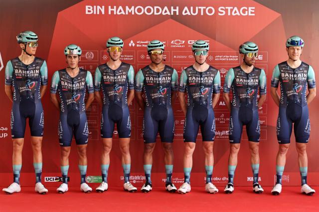 Team Bahrain Victorious' riders pose on the stage ahead of the first stage of the UAE Tour cycling event from Madinat Zayed Majlis to Liwa Palace in Abu Dhabi on February 16, 2026. (Photo by Fadel SENNA / AFP)