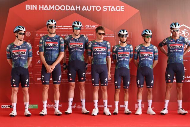 Team Soudal Quick-Step's riders pose on the stage ahead of the first stage of the UAE Tour cycling event from Madinat Zayed Majlis to Liwa Palace in Abu Dhabi on February 16, 2026. (Photo by Fadel SENNA / AFP)