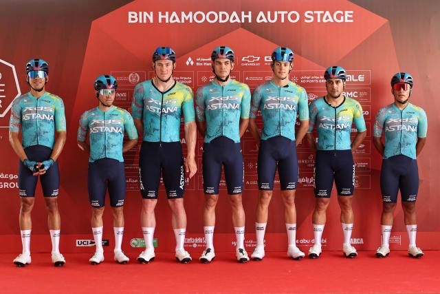 Team XDS Astana's riders pose on the stage ahead of the first stage of the UAE Tour cycling event from Madinat Zayed Majlis to Liwa Palace in Abu Dhabi on February 16, 2026. (Photo by Fadel SENNA / AFP)