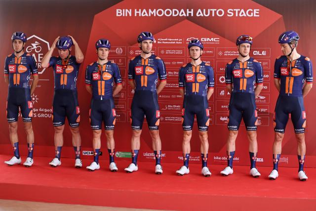 Team Picnic PostNL's riders pose on the stage ahead of the first stage of the UAE Tour cycling event from Madinat Zayed Majlis to Liwa Palace in Abu Dhabi on February 16, 2026. (Photo by Fadel SENNA / AFP)