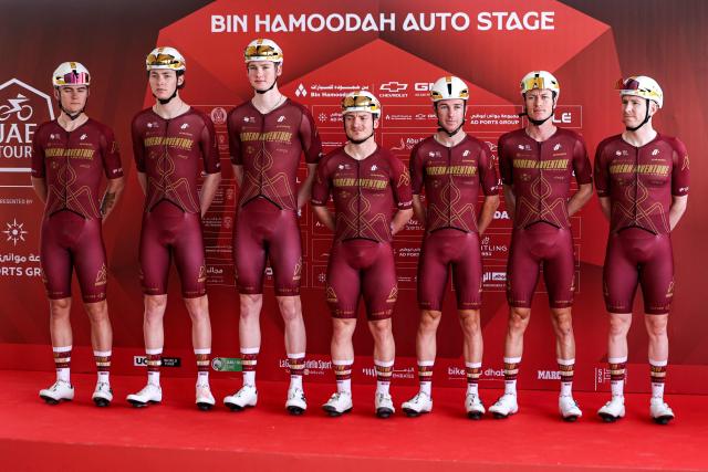 Team Modern Adventure Pro Cycling's riders pose on the stage ahead of the first stage of the UAE Tour cycling event from Madinat Zayed Majlis to Liwa Palace in Abu Dhabi on February 16, 2026. (Photo by Fadel SENNA / AFP)