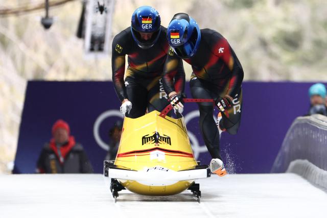 Germany's Johannes Lochner and Germany's Georg Fleischhauer compete in the bobsleigh men's 2-man heat 1 at Cortina Sliding Centre during the Milano Cortina 2026 Winter Olympic Games in Cortina d'Ampezzo on February 16, 2026. (Photo by FRANCK FIFE / AFP)