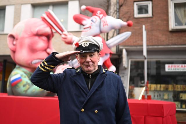 German carnival float builder Jacques Tilly poses for photographers in front of one his creation, a carnival float featuring Russian President Vladimir Putin, during the parade to celebrate Rose Monday (Rosenmontag), on February 16, 2026 in Duesseldorf, western Germany. (Photo by INA FASSBENDER / AFP)