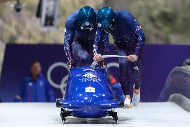 Britain's Brad Hall and Britain's Taylor Lawrence compete in the bobsleigh men's 2-man heat 1 at Cortina Sliding Centre during the Milano Cortina 2026 Winter Olympic Games in Cortina d'Ampezzo on February 16, 2026. (Photo by FRANCK FIFE / AFP)