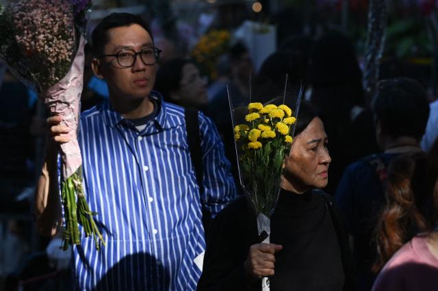 People shop for flowers at the Mongkok flower market on the eve of the Lunar New Year of the Horse in Hong Kong on February 16, 2026. (Photo by Peter PARKS / AFP)