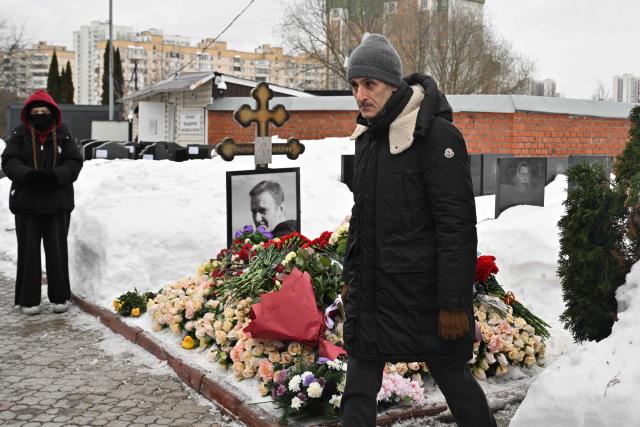 French embassy official Thomas Zacharie Gross-Huguet visits the grave of Russian opposition leader Alexei Navalny at the Borisovo cemetery in Moscow on February 16, 2026, marking the second anniversary of his death in an Arctic colony. (Photo by Hector RETAMAL / AFP) / NAVALNY HAS BEEN DECLARED "EXTREMIST" BY RUSSIAN AUTHORITIES. IN RUSSIA, ANYBODY WHO MENTIONS NAVALNY OR HIS ANTI-CORRUPTION FOUNDATION WITHOUT STATING THAT THEY HAVE BEEN DECLARED "EXTREMIST" IS SUBJECT TO FINES OR UP TO FOUR YEARS IN PRISON FOR REPEATED OFFENCES. / 