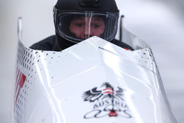 Austria's Jakob Mandlbauer and Austria's Daiyehan Nichols-Bardi (unseen)compete in the bobsleigh men's 2-man heat 1 at Cortina Sliding Centre during the Milano Cortina 2026 Winter Olympic Games in Cortina d'Ampezzo on February 16, 2026. (Photo by FRANCK FIFE / AFP)