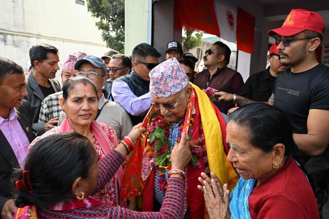 Supporters honour Khadga Prasad Sharma Oli (C), Nepal's former prime minister and Communist Party of Nepal-Unified Marxist Leninist (CPN-UML) leader, during his door-to-door election campaign rally in Damak, Jhapa district on February 16, 2026. Nepali candidates launch their campaigns on February 16 for March 5 parliamentary elections, the first since deadly anti-corruption protests toppled the previous government in 2025. (Photo by Prakash MATHEMA / AFP)