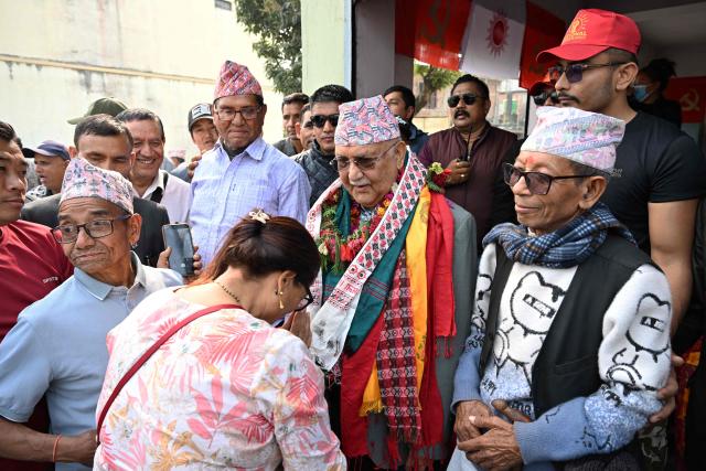 Khadga Prasad Sharma Oli (C), Nepal's former prime minister and Communist Party of Nepal-Unified Marxist Leninist (CPN-UML) leader, greets supporters during a door-to-door election campaign rally in Damak, Jhapa district on February 16, 2026. Nepali candidates launch their campaigns on February 16 for March 5 parliamentary elections, the first since deadly anti-corruption protests toppled the previous government in 2025. (Photo by Prakash MATHEMA / AFP)