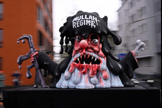 A carnival float designed by German carnival float builder Jacques Tilly featuring a Mullah is pictured during the parade to celebrate Rose Monday (Rosenmontag), on February 16, 2026 in Duesseldorf, western Germany. (Photo by INA FASSBENDER / AFP)