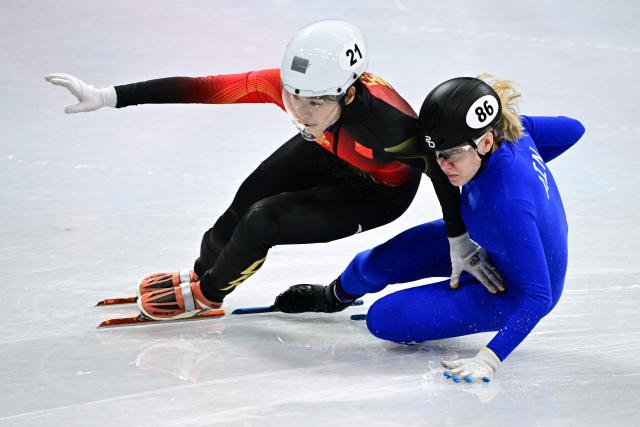 China's Zhang Chutong and Individual Neutral Athlete Alena Krylova crash in the short track speed skating women's 1000m quarter-final during the Milano Cortina 2026 Winter Olympic Games at Milano Ice Skating Arena in Milan on February 16, 2026. (Photo by JULIEN DE ROSA / AFP)
