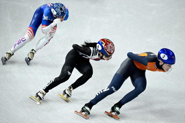 Netherlands' Xandra Velzeboer, South Korea's Kim Gil-li and USA's Kristen Santos-Griswold compete in the short track speed skating women's 1000m quarter-final during the Milano Cortina 2026 Winter Olympic Games at Milano Ice Skating Arena in Milan on February 16, 2026. (Photo by WANG Zhao / AFP)