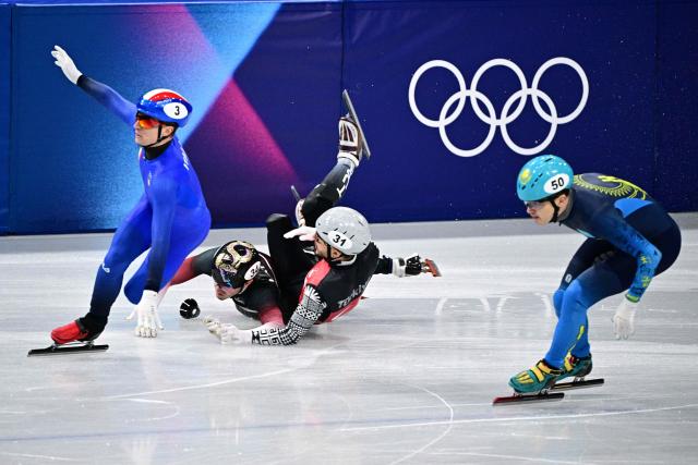 Italy's Pietro Sighel, Latvia's Reinis Berzins, Turkey's Furkan Akar crash as Kazakhstan's Abzal Azhgaliyev skates past them during the short track speed skating men's 500m heats during the Milano Cortina 2026 Winter Olympic Games at Milano Ice Skating Arena in Milan on February 16, 2026. (Photo by JULIEN DE ROSA / AFP)