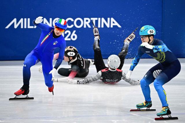 Italy's Pietro Sighel, Latvia's Reinis Berzins, Turkey's Furkan Akar and Kazakhstan's Abzal Azhgaliyev crash during the short track speed skating men's 500m heats during the Milano Cortina 2026 Winter Olympic Games at Milano Ice Skating Arena in Milan on February 16, 2026. (Photo by JULIEN DE ROSA / AFP)