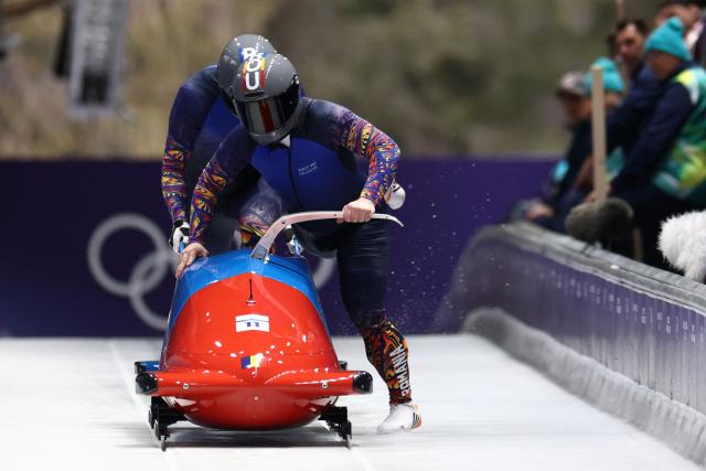 Romania's Mihai Cristian Tentea and Romania's George Iordache compete in the bobsleigh men's 2-man heat 1 at Cortina Sliding Centre during the Milano Cortina 2026 Winter Olympic Games in Cortina d'Ampezzo on February 16, 2026. (Photo by FRANCK FIFE / AFP)