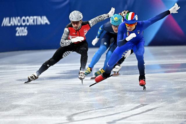 Italy's Pietro Sighel and Turkey's Furkan Akar compete in the short track speed skating men's 500m heats during the Milano Cortina 2026 Winter Olympic Games at Milano Ice Skating Arena in Milan on February 16, 2026. (Photo by Gabriel BOUYS / AFP)