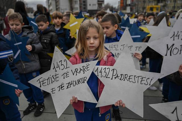 Kosovo Albanian children hold stars with the names of the children killed and missing during the Kosovo war in 1998-1999 as they march ahead of the Kosovo Independence anniversary celebrations in Pristina on February 16, 2026. (Photo by Armend NIMANI / AFP)