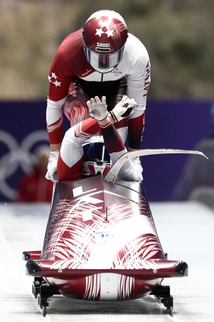 Latvia's Jekabs Kalenda and Latvia's Matiss Miknis compete in the bobsleigh men's 2-man heat 1 at Cortina Sliding Centre during the Milano Cortina 2026 Winter Olympic Games in Cortina d'Ampezzo on February 16, 2026. (Photo by FRANCK FIFE / AFP)