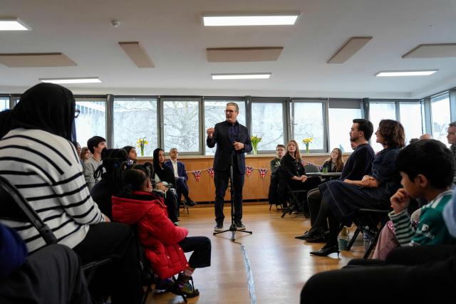 Britain's Prime Minister Keir Starmer (C) speaks to local residents during a visit to a community centre at St Mary’s Church in Putney, southwest London on February 16, 2026. (Photo by CARLOS JASSO / POOL / AFP)