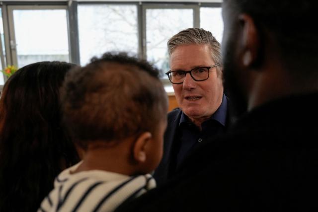 Britain's Prime Minister Keir Starmer (back R) meets with local residents during a visit to a community centre at St Mary’s Church in Putney, southwest London on February 16, 2026. (Photo by CARLOS JASSO / POOL / AFP)