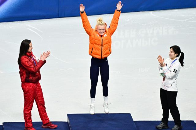 Gold medallist Netherlands' Xandra Velzeboer jumps on the podium of the short track speed skating women's 1000m final during the Milano Cortina 2026 Winter Olympic Games at Milano Ice Skating Arena in Milan on February 16, 2026. (Photo by JULIEN DE ROSA / AFP)
