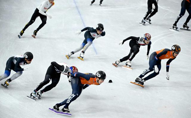 Netherlands' Teun Boer, South Korea's Lee Jeong-min and Japan's Kazuki Yoshinaga compete in the short track speed skating men's 5000m relay semi-final during the Milano Cortina 2026 Winter Olympic Games at Milano Ice Skating Arena in Milan on February 16, 2026. (Photo by WANG Zhao / AFP)
