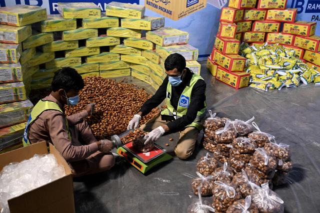 Volunteers from the Alkhidmat Foundation Pakistan prepare ration packs for economically disadvantaged families before the start  of the holy fasting month of Ramadan in Lahore on February 16, 2026. (Photo by Arif ALI / AFP)