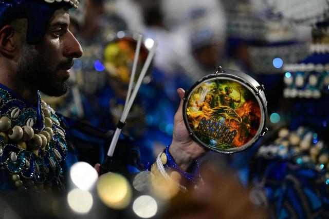 Revellers of the Portela samba school perform during the opening night of the Rio Carnival at the Marques de Sapucai Sambadrome in Rio de Janeiro, Brazil, on February 16, 2026. (Photo by Pablo PORCIUNCULA / AFP)