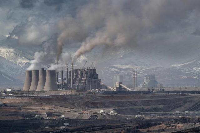 Mining vehicles extract coal from a lignite coal mine, as the Elbistan thermal power plant, is seen in the background in Elbistan on February 11, 2026. The power plant has operated since 1984 and is one of Turkey's largest thermal facilities, with eight units generating 2,795 megawatts. It relies on lignite from the Afsin?Elbistan basin, which holds around 40 percent of the country's known reserves. (Photo by Ozan KOSE / AFP)