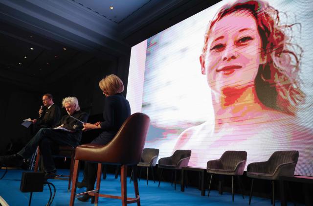 An image of Renée Nicole Good, a 37-year-old American woman who was fatally shot in Minneapolis by United States Immigration and Customs Enforcement (ICE), appears on a screen, as the founder the Cinema For Peace foundation Jaka Bizilj (L) and Irish singer-songwriter and political activist Bob Geldof sit on stage during the "World Forum 2026 on the "Future of Democracy, AI/Tech, and Humankind" as part of the "Cinema for Peace" events in Berlin, on February 16, 2026. (Photo by Adam BERRY / AFP)
