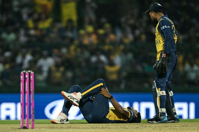 Sri Lanka's Matheesha Pathirana (L) suffers a leg injury as wicketkeeper Kusal Mendis watches during the 2026 ICC Men's T20 Cricket World Cup group stage match between Australia and Sri Lanka at Pallekele International Cricket Stadium in Kandy on February 16, 2026. (Photo by Ishara S. KODIKARA / AFP)