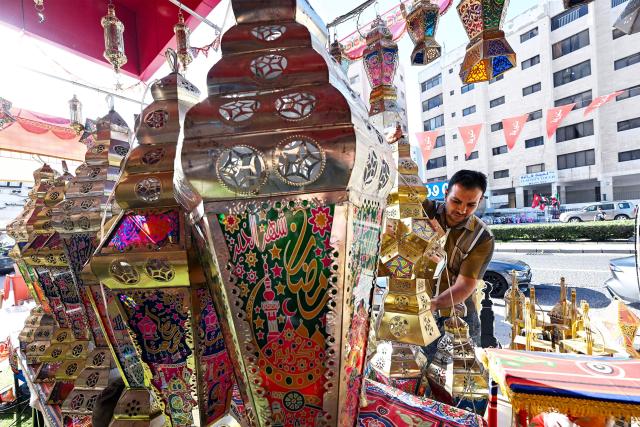 A vendor arranges decorations outside his shop at a market in Kuwait City on February 16, 2026, as Muslims prepare for the holy month of Ramadan. For Muslims across the world, the beginning of the ninth month in the Muslim lunar calendar which marks the start of Ramadan, is a time for spiritual reflection, prayers, fasting and family reunions around the table after breaking the fast. (Photo by YASSER AL-ZAYYAT / AFP)