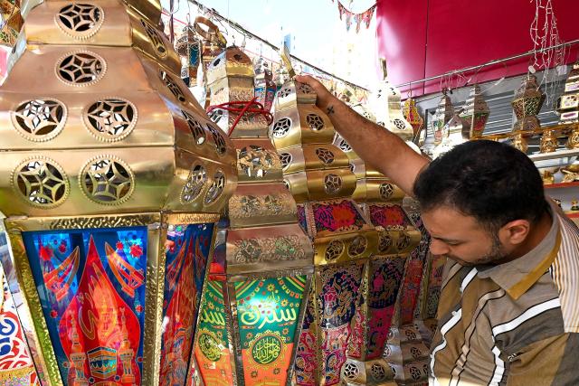 A vendor arranges decorations outside his shop at a market in Kuwait City on February 16, 2026, as Muslims prepare for the holy month of Ramadan. For Muslims across the world, the beginning of the ninth month in the Muslim lunar calendar which marks the start of Ramadan, is a time for spiritual reflection, prayers, fasting and family reunions around the table after breaking the fast. (Photo by YASSER AL-ZAYYAT / AFP)