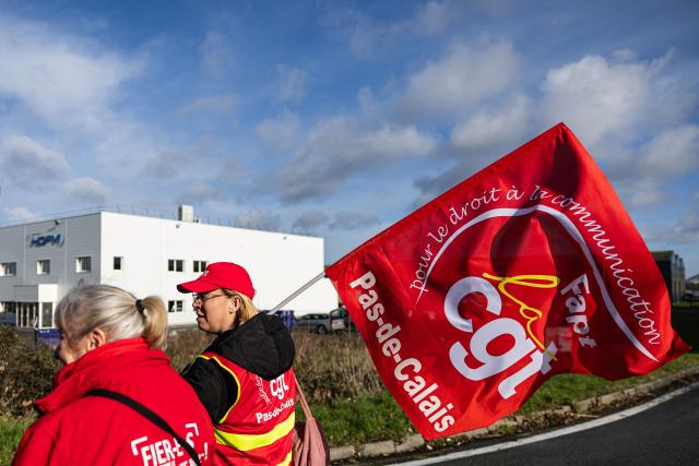 Protesters hold CGT union flags as they take part in a rally on the eve of the formal submission of takeover offers for glassmaking giant Arc in Arques, northern France, on February 16, 2026. Around 500 Arc employees and political figures demonstrated in Arques (Pas-de-Calais) on February 16, 2026, on the eve of the deadline for submitting takeover bids for the glassmaker, which was placed in receivership in early January. (Photo by Sameer Al-DOUMY / AFP)