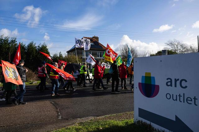 Protesters hold CGT and CGC union flags as they take part in a rally on the eve of the formal submission of takeover offers for glassmaking giant Arc in Arques, northern France, on February 16, 2026. Around 500 Arc employees and political figures demonstrated in Arques (Pas-de-Calais) on February 16, 2026, on the eve of the deadline for submitting takeover bids for the glassmaker, which was placed in receivership in early January. (Photo by Sameer Al-DOUMY / AFP)
