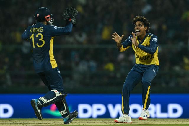 Sri Lanka's Dunith Wellalage (R) celebrates with wicketkeeper Kusal Mendis after taking the wicket of Australia's Cameron Green during the 2026 ICC Men's T20 Cricket World Cup group stage match between Australia and Sri Lanka at Pallekele International Cricket Stadium in Kandy on February 16, 2026. (Photo by Ishara S. KODIKARA / AFP)
