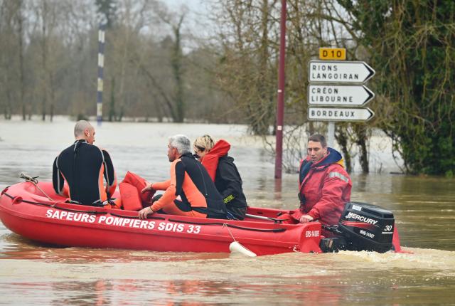 Firefighters patrol on a boat on their way to rescue residents in the city center flooded by the Garonne river in Cadillac-sur-Garonne, southwestern France, on February 16, 2026. The flood alert system in France has been working at a record pace as relentless rain over the past month has saturated soils, the head of the agency told AFP on February 14, 2026. "For 30 days we have been in continuous orange or red alert somewhere on the national territory," Lucie Chadourne-Facon, director of Vigicrues, told AFP, referring to the two highest alert levels. (Photo by Gaizka IROZ / AFP)