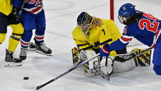 USA's forward #24 Joy Dunne (R) passes the puck to USA's forward #27 Taylor Heise (2nd L) during the women's play-off semi-final ice hockey match between USA and Sweden at the Milano Santagiulia Ice Hockey Arena during the Milano Cortina 2026 Winter Olympic Games in Milan, on February 16, 2026. (Photo by Alexander NEMENOV / AFP)