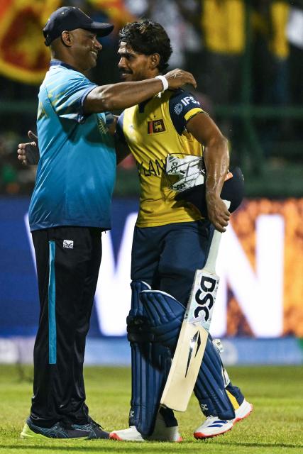 Sri Lanka's Pathum Nissanka (R) is congratulated by head coach Sanath Jayasuriya for his innings as they celebrate their team's win against Australia at the end of their 2026 ICC Men's T20 Cricket World Cup group stage match in the Pallekele International Cricket Stadium, Kandy on February 16, 2026. (Photo by Ishara S. KODIKARA / AFP)