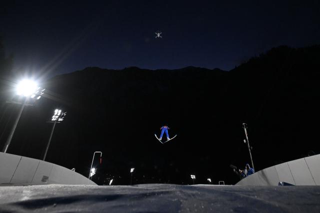 An athlete jumps during the trial round of the men's large hill super team ski jumping of the Milano Cortina 2026 Winter Olympic Games at Predazzo Ski Jumping Stadium in Predazzo (Val di Fiemme), on February 16, 2026. (Photo by Javier SORIANO / AFP)