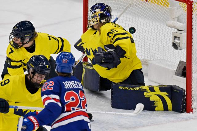 Sweden's #01 Ebba Svensson Traff misses to stop USA's fourth goal shot by USA's defender #10 Laila Edwards during the women's play-off semi-final ice hockey match between USA and Sweden at the Milano Santagiulia Ice Hockey Arena during the Milano Cortina 2026 Winter Olympic Games in Milan, on February 16, 2026. (Photo by Alexander NEMENOV / AFP)