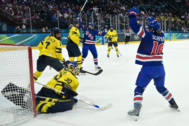 USA's forward #16 Hayley Scamurra celebrates with teammates after scoring her team's fifth goal during the women's play-off semi-final ice hockey match between USA and Sweden at the Milano Santagiulia Ice Hockey Arena during the Milano Cortina 2026 Winter Olympic Games in Milan, on February 16, 2026. (Photo by PIERO CRUCIATTI / AFP)
