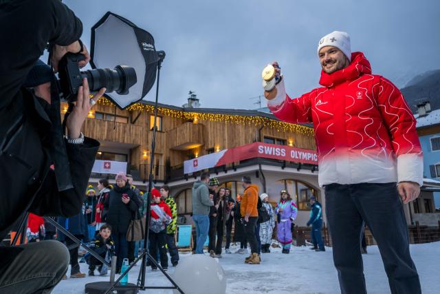 Switzerland's Loic Meillard poses with his medals at the hotel of the Swiss team after winning the men's slalom alpine skiing event during the Milano Cortina 2026 Winter Olympic Games at the Stelvio Ski Centre in Bormio (Valtellina) on February 16, 2026. (Photo by Fabrice COFFRINI / AFP)