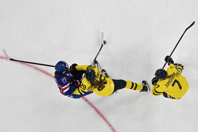 USA's forward #17 Britta Curl (L) fights for the puck with Sweden's #29 Felizia Wikner Zienkiewicz (C) and Sweden's #07 Mira Jungaker (R) during the women's play-off semi-final ice hockey match between USA and Sweden at the Milano Santagiulia Ice Hockey Arena during the Milano Cortina 2026 Winter Olympic Games in Milan, on February 16, 2026. (Photo by Alexander NEMENOV / AFP)