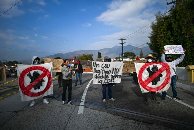 University students and members of civil society demonstrate outside a hotel as University of San Carlos officials meet to appoint Constitutional Court magistrates, protesting the possible selection of Attorney General Consuelo Porras, in Antigua, Guatemala, on February 16, 2026. Guatemala has begun the process to renew members of key judicial institutions, including its top court and the Prosecutor's Office, which for years have been suspected of protecting a network of corruption and criminal activity. (Photo by JOHAN ORDONEZ / AFP)
